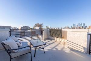 Un balcón con una silla y una mesa en el techo. en Beautiful Lux 4 Bedroom*Near PENN/CHOP*Roof Deck, en Filadelfia