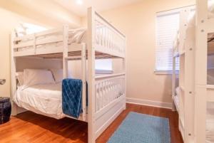 a bedroom with two bunk beds and a window at Beautiful Lux 4 Bedroom*Near PENN/CHOP*Roof Deck in Philadelphia