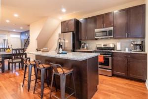 a kitchen with a large island with bar stools at Beautiful Lux 4 Bedroom*Near PENN/CHOP*Roof Deck in Philadelphia