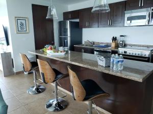 a kitchen with a counter with stools in it at Big Luxury Condo - Zona Dorada in Mazatlán
