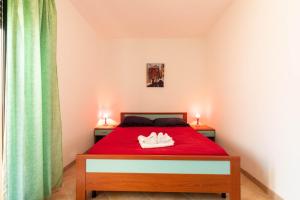 ヴィッラシミーウスにあるAppartamenti Cavour Codice Eのベッドルーム1室(赤いベッド1台、靴2本付)