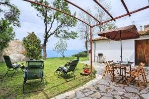 een patio met stoelen, een tafel en een parasol bij Casa La Capraia in Zanca