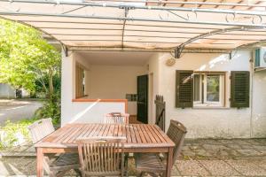 a wooden table and chairs in front of a house at Monolocale casa Lucia in Campo nell'Elba
