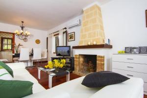 a living room with a white couch and a fireplace at Can Domingo in Pollença