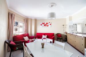 コニル・デ・ラ・フロンテーラにあるApartamento Goya 1ºのリビングルーム(白いテーブル、赤いソファ付)