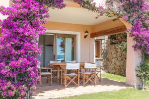 patio con tavolo e fiori viola di Poggio Dei Fiori Appartamento G2 a Olbia