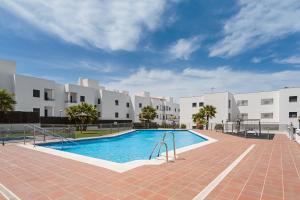 a swimming pool in front of some white buildings at Apartamento Cañada Honda Conil in Conil de la Frontera