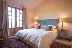 a bedroom with a large white bed with a large window at La Maison in Villeneuve-de-Duras +18 photos
