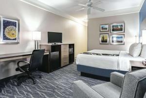 Pokój hotelowy z łóżkiem, biurkiem i telewizorem w obiekcie La Quinta by Wyndham Phoenix I-10 West w mieście Phoenix