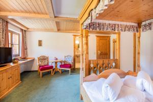 ein Schlafzimmer mit einem Himmelbett und einem Tisch in der Unterkunft Hotel Winklerhof in Holzgau