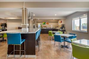 a kitchen with blue and green chairs and a bar at Quality Inn & Suites in Bathurst