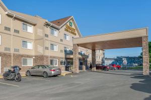 a car parked in a parking lot in front of a hotel at Quality Inn & Suites in Bathurst