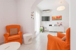 コニル・デ・ラ・フロンテーラにあるApartamento Batelesのリビングルーム(オレンジの椅子、テーブル付)