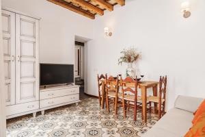 a living room with a dining room table and a tv at Casa de los Abuelos 20 in Vejer de la Frontera
