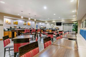 a restaurant with wooden tables and red chairs at Comfort Suites Hopkinsville near Fort Campbell in Hopkinsville