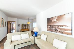 een woonkamer met 2 stoelen en een schilderij aan de muur bij Villa Eduard in Binibeca