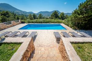 una piscina con tumbonas y una piscina en Sa Lluna, en Sant Josep