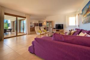 sala de estar con sofá púrpura y TV en Sa Lluna, en Sant Josep