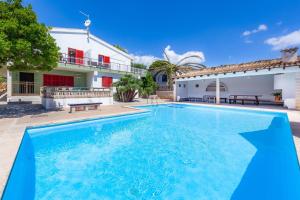 a swimming pool in front of a house at Es Pins Gran in Font de Sa Cala