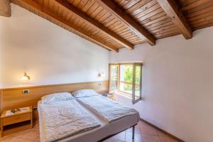 sypialnia z łóżkiem i oknem w obiekcie Casa Rita app 2 w Tremosine Sul Garda