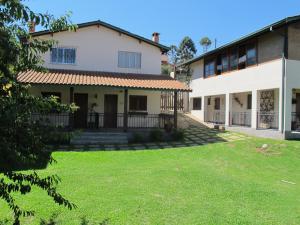a house with a lawn in front of it at Pousada Vilas di Espanha in Monte Verde