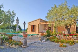 a house with a garden with flowers in front of it at Casa Maria in Alcudia