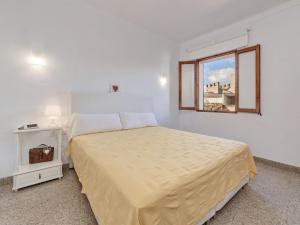 a white bedroom with a bed and a window at Casa Convent in Alcudia