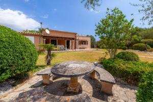 uma mesa de pedra no quintal de uma casa em Can Me Sents em Pollença