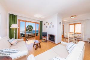 a living room with white furniture and a view of the ocean at Mastil in Cala Millor