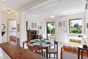 a dining room and living room with a table and chairs at Il giardino nel sole Bilo in Capoliveri