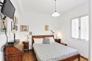 a bedroom with a bed and a flat screen tv at Il giardino nel sole Trilo in Capoliveri