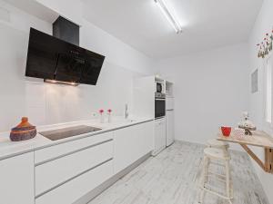 a white kitchen with a sink and a counter at Casa Convent in Alcudia