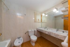 a bathroom with a toilet and two sinks and a mirror at Mastil in Cala Millor +26 photos