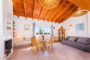 ein Wohnzimmer mit Tisch und Stühlen und einer Couch in der Unterkunft Santa María in Artá