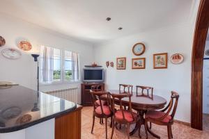 a kitchen with a table and chairs and a tv at Villa en Son Gall Ciutadella in Ciutadella