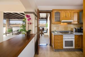 Una cocina con gabinetes de madera y encimera. en Aguamarina 4, en Playa Blanca