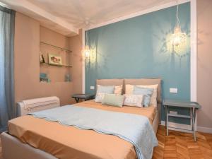 a bedroom with a large bed with a blue wall at Luxury modern apartment by the lake in Salò