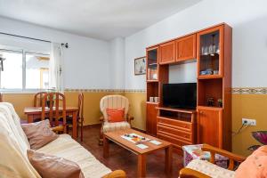 un soggiorno con divano e TV di Apartamento Rocio - solo familias a Conil de la Frontera