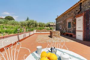 un patio con una mesa con fruta. en Malicodia en Santa Maria di Licodia