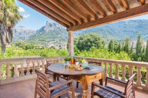 a table on a balcony with a view of mountains at Can Guixa in Sóller