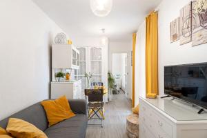- un salon avec un canapé et une télévision dans l'établissement Apartamento Los Girasoles, à Vejer de la Frontera