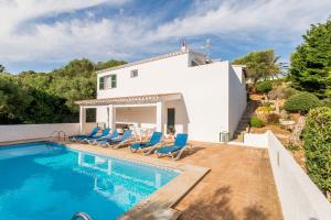 a villa with a swimming pool and blue chairs at Villa Mariola in Binibeca