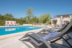 a pair of lawn chairs sitting next to a swimming pool at Sa Caseta den Tronca in Sant Joan
