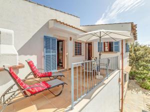 a patio with two chairs and an umbrella at Es Romaní in Cala Ratjada