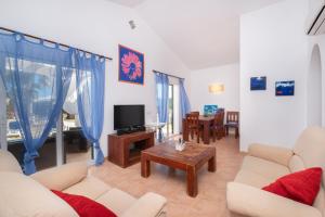 uma sala de estar com um sofá e uma televisão em Chalet con piscina en Menorca em Cala'n Bosch