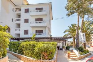 a large white building with trees in front of it at Apartamento La Cabanya 2b in Canyamel