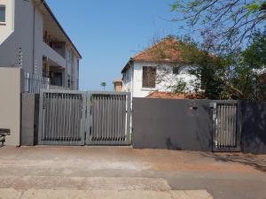 ein Tor vor einem weißen Haus mit einem Haus in der Unterkunft ARCHITECTs VIEW - SUIT 2 in Durban