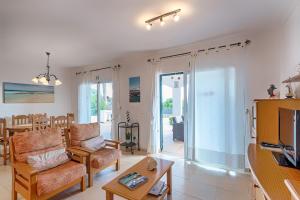 a living room with a couch and a tv at Villa Bini Tuduri in Binibeca