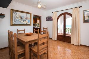 een eetkamer met een tafel en stoelen en een raam bij Villa Belvedere 76 in Son Bou