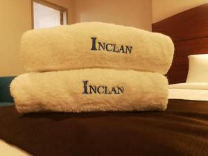 una pila de toallas sentadas encima de una cama en Hotel Inclan, en Lima